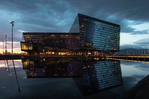 Harpa met zijn reflectie in de haven van Reykjavik