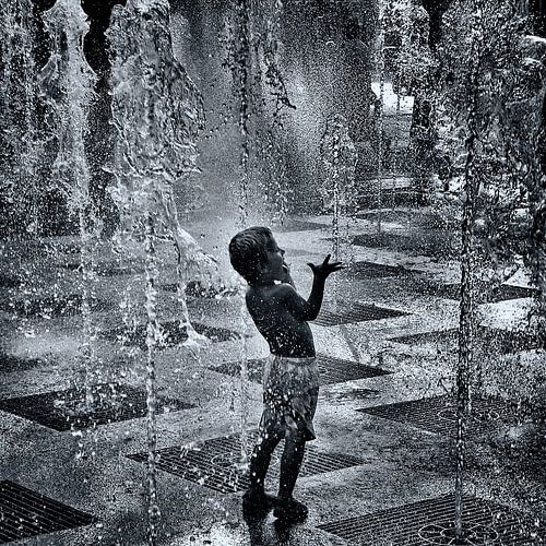 Kind spielt in dem Brunnen