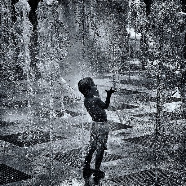 Kind spielt in dem Brunnen von Ipo Reinhold