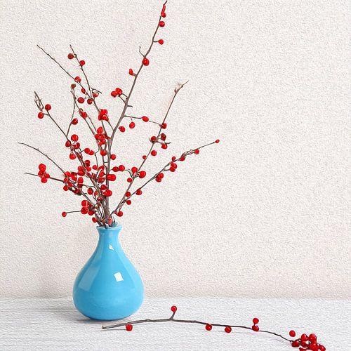 Elegant Display of Bright Red Berries in a Stylish Blue Vase