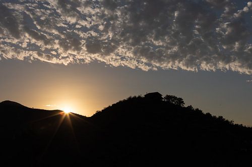 Zonsondergang met bergen en bewolking