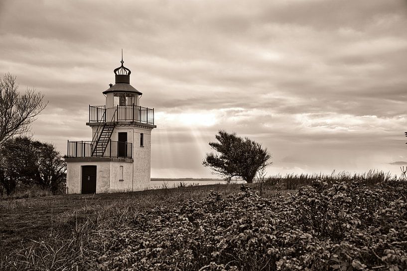Lighthouse by the sea and rays of sunshine by Martin Köbsch