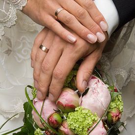 Mains d'un couple de mariés sur le bouquet de la mariée sur Jörg B. Schubert