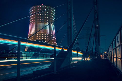 Lange Belichtung eines vorbeifahrenden Busses mit beleuchtetem Kühlturm