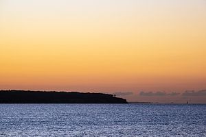 Zonsondergang aan de kust van de Oostzee in Warnemünde van Rico Ködder