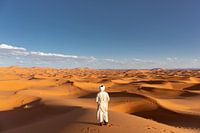 African man looks out over the dunes of the African desert, the Sahara