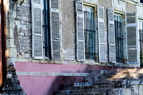 Vensters met diefijzers en luiken in een oude kasteelgevel