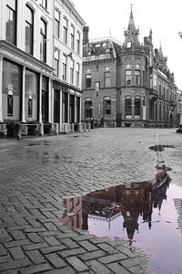 Zwartwit foto van toren aan de Pausdam in Utrecht met gekleurde weerspiegeling in de plas. van Phillipson Photography