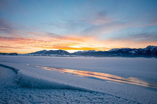 Zonsopgang over de bevroren Forggensee en de oostelijke Allgäuer Alpen
