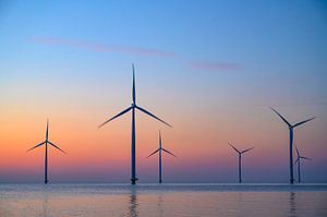 Windturbinen in einem Offshore-Windpark bei Sonnenuntergang