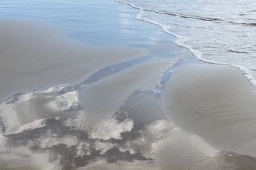 Spiegelung der Wolken im nassen Sand