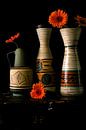Foto van een stilleven met jaren 60 vazen en oranje gerbera's. van Therese Brals thumbnail