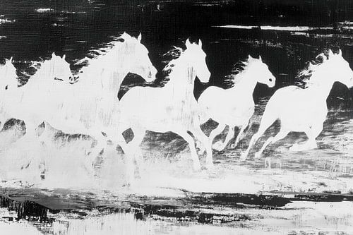 Witte paarden rennen langs de kustlijn