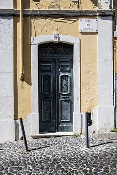 Gele muur met deur in Lissabon van Jessica Arends