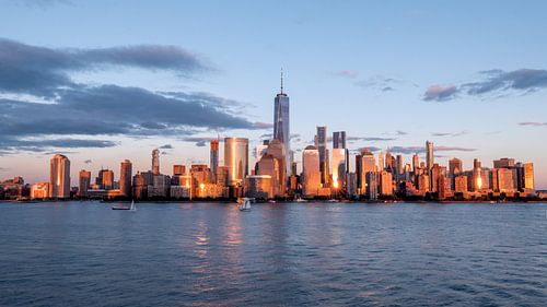 New york city skyline daytime sun clouds blue golden hour