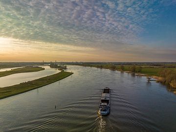 Ship sailing on the river IJssel during sunset