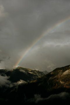 Rainbow on mountain peak with dark sky by Colinda Riemens