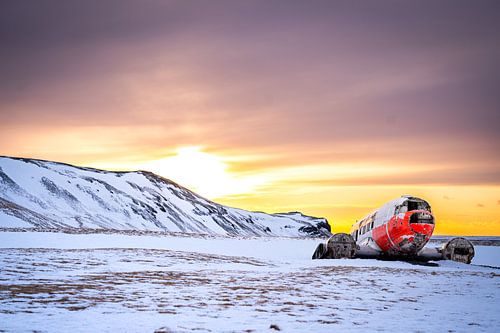 DC-3 vliegtuigwrak in besneeuwd landschap bij zonsondergang, Eyvindarholt, IJsland