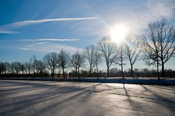 Zonnige winterdag | blauwe lucht boven een bevroren kanaal van Marcel Mooij
