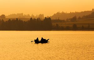 Zwei Angler im Ruderboot auf dem See im Sonnenuntergang