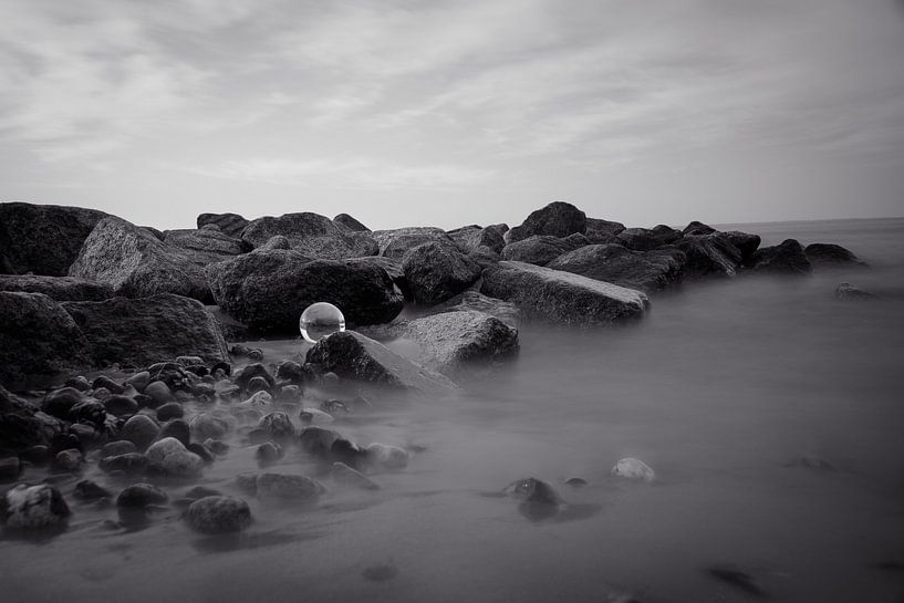 De glazen bol op de rotsen in de zee van Marc-Sven Kirsch