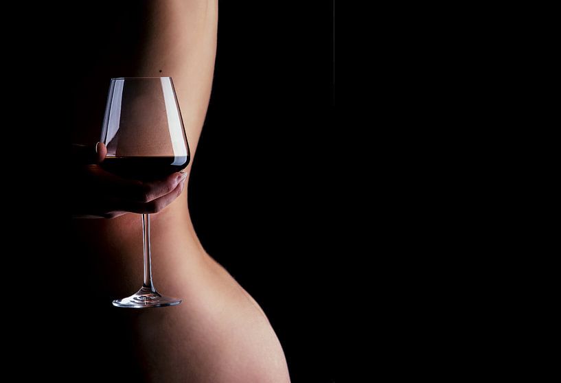 Een foto van een naakte vrouw die een glas wijn vasthoudt achter haar rug.  by Retinas images