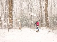 Mann mit rotem Rucksack im Schnee