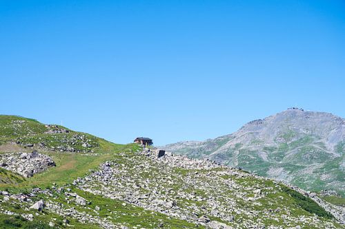 Maison isolée sur une prairie de montagne dans les Alpes françaises.