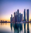 De zon komt op achter de skyline van Dubai van Rene Siebring thumbnail