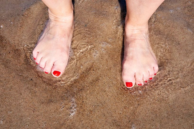 Feet of a woman on the beach by Heiko Kueverling