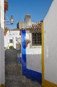 Une ruelle à Óbidos (Portugal) en bleu, jaune et blanc