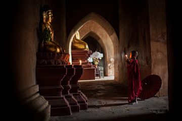 Jonge monnik in Bagan Myanmar bidt voor een beeld van Budha. Wout Kok One2expose Photography van Wout Kok