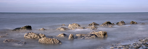 Rotsblokken aan de branding van de Noordzee