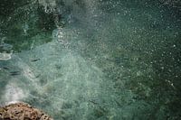 Grün-blaues Wasser mit Fischen und Blasen