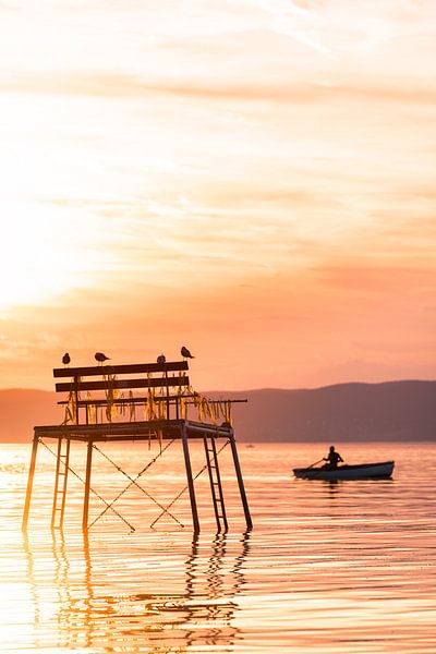 Sportvissers in een roeiboot bij zonsondergang aan het Balatonmeer in Hongarije Fonyód van Daniel Pahmeier