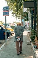 Älterer Mann geht auf einer sonnenbeschienenen Straße in der Türkei spazieren
