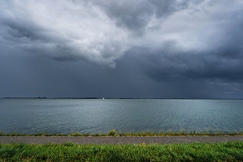 Donkere wolken boven zeilbootje Oosterschelde