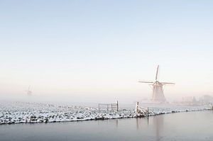 Wit winterlandschap met een molen en sneeuw en ijs