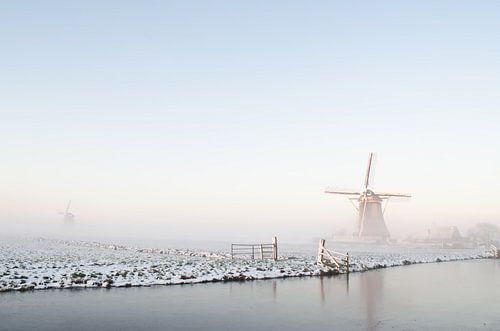 Wit winterlandschap met een molen en sneeuw en ijs
