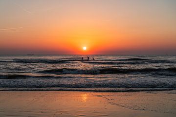 Surfers op het strand van Noordwijk tijdens een zonsondergang (0072) van Reezyard