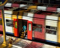 Man boards train at Liege station (Liege) In coloured light