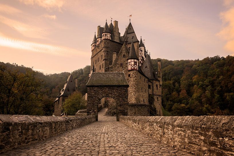Met kasseien geplaveide straat naar Burg Eltz kasteel in het ochtendlicht van iPics Photography