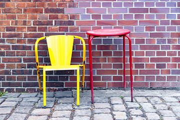 Stuhl und Tisch vor einer Ziegelwand - Stillleben von Frank Herrmann