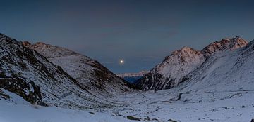 De volle maan aan de Engadiner hemel boven de winterse Flüela Pass