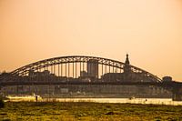 Waalbrücke bei Sonnenuntergang mit der Stadt Nimwegen im Hintergrund.