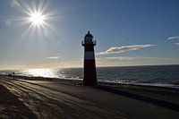 Vuurtoren aan de nederlandse kust met een mooie zon.