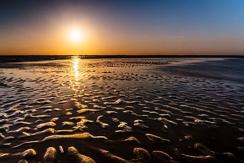 Colorful Sunset by the Sea with sand waves in the foreground
