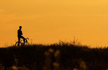 Silhouette eines Radfahrers, der Pause macht