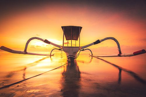 Prachtige klassieke Aziatische vissersboot op het strand van Bali in Sanur. De Jukung ligt bij zonso