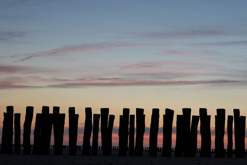 golfbrekers met ondergaande zon op het strand in zeeland by Frans Versteden